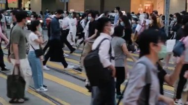 Hong Kong 'da tıbbi maske takan tanınmamış insanların yavaş hareket etmesi.. 