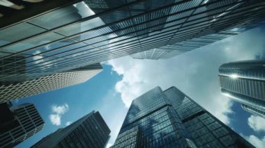 Şehir ufuk çizgisi binaları, mavi gökyüzü ve cam aynalı cephelerin düşük açılı görüntüsü.