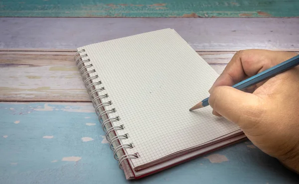 Asian man hand is writing on notebook
