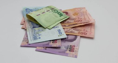 Beyaz arka plana yerleştirilmiş birçok Tayland banknotunu kapat