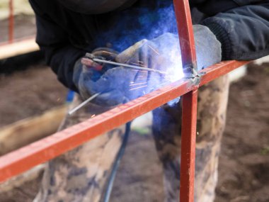 Metal yapılar elle kaynak yaparak açık havada toplanıyor.