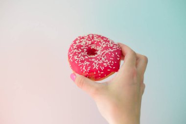 Elinde Pembe Donut, renkli arkaplan