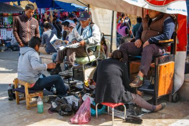 Meksika 'nın Oaxaca bölgesindeki Tlacolula köyünde ayakkabı temizleyicileri sıkı çalışıyor.