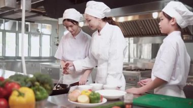 Beyaz kadın usta aşçı, stajyer öğrenci kızları eğitir ve kızdırır. Kızarmış pilav pişirir ve restoran mutfağında tadımlık verir. Lezzetli yemeklerde profesyonel gurme ve mutfak yemekleri..