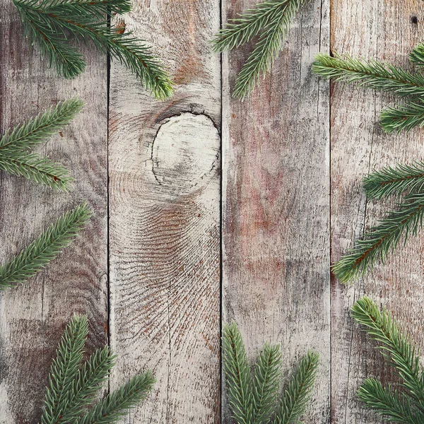 Shabby wood panels background. Fir tree branches on old barn wooden floor. Winter season frame. Holiday poster backdrop. Rustic timber table border with conifer plant elements. Light wood texture