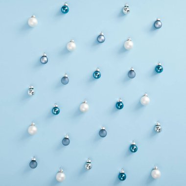 Noel minimalist şablonu - mavi arka planda beyaz, gümüş ve mavi takılar. Kare kompozisyon, düz döşeme, üst manzara. Baskı tasarımı için modern tasarım şablonu. Noel renk tebrik kartı şablonu