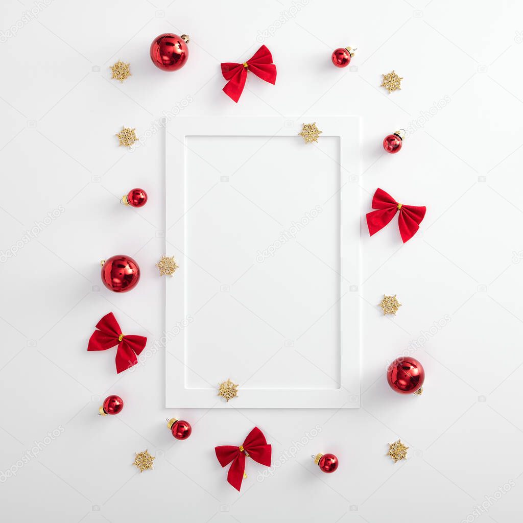 Christmas minimal mockup - red xmas ball, bow and gold snowflake on white background. Square composition with vertical white paper frame. Flat lay, top view. Red, gold and white layou