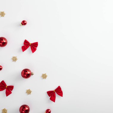 Minimum Noel modeli. Kırmızı Xmas topu, yay ve beyaz arka planda altın kar tanesi. Kare kompozisyon ve Xmas köşe dekorasyonu. Düz yerde, üst tarafta. Kırmızı, altın ve beyaz şablon