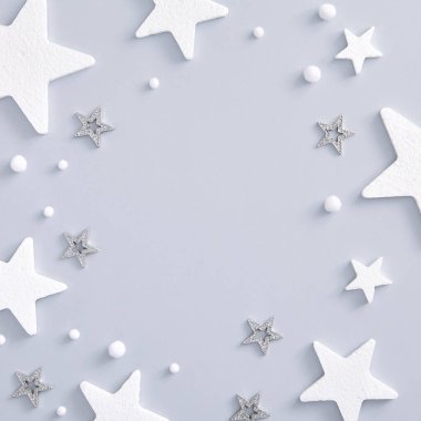 Noel için en az model, beyaz ve gümüş yıldızlı monokrom düzeni. Kare kompozisyon, düz döşeme, üst manzara. Uzayı kopyala Tatil maketi. Kış mevsimi.