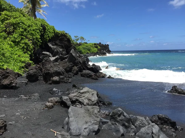 由绿色植物构成的黑色沙滩的照片 可看到夏威夷碧绿的太平洋 — 图库照片