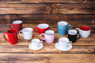 Koyu ahşap desenli arka planda çok renkli bardaklar. Yukarıdan görüntüle