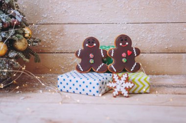 Noel kompozisyonu hediyeler ve ahşap arka planda zencefilli çörekler.