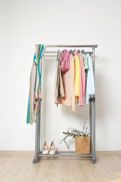 Spring fashion - pastel colored clothes on rail. Female colorful bright spring clothing set of on the racks on white background. Sale at clothing store concept.