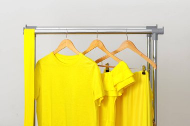 Parlak sarı yazlık giysiler korkulukta asılı. Neşeli, pozitif bir kadın kıyafeti. Tatil için kıyafet, denizde dinlenme, yaz yürüyüşleri..