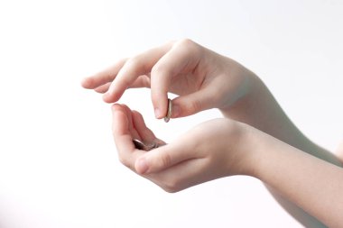 Bir elinde küçük bir miktar para, diğer elinde ise arka planda hafif bir madeni para tutuyor.