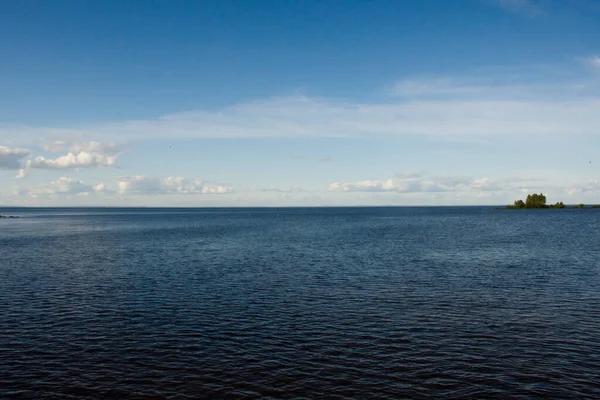 Ciel bleu avec des nuages blancs sur le lac et l'île. Eau bleue avec ondulations, concept de voyage — Photo