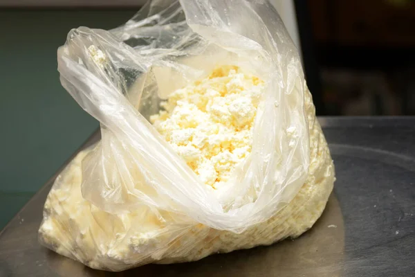 Elektronik ölçekte plastik bir torba içinde süzme peynir tartmak. Tarım ürünleri ticareti. Küçük işletme kavramı.