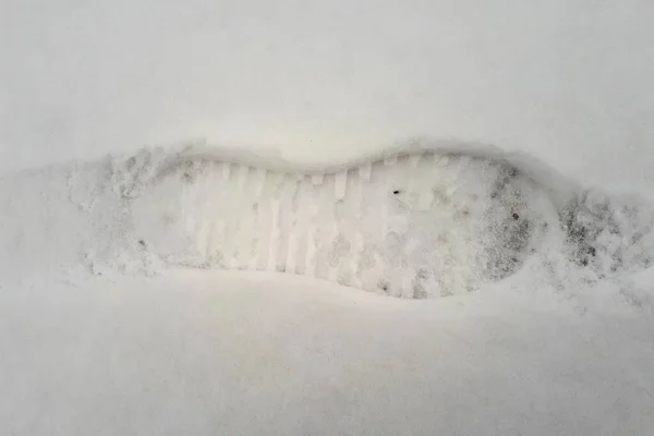 新鮮な雪を足跡 白い雪の中で足跡 人間の痕跡を持つ白い雪 白い雪の上の人間の足跡のトップビュー — ストック写真