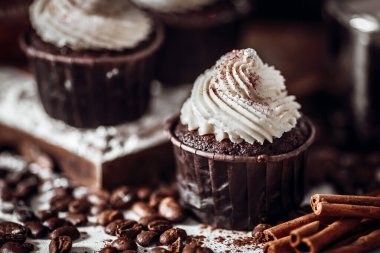 Kahve çekirdekleri ve tarçın arasındaki masada çikolatalı kek.