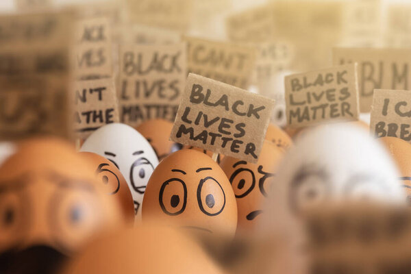Cartoon eggs with faces participating in a meeting black lives matter