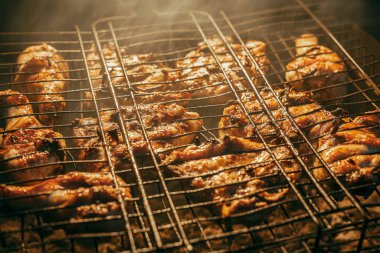 Birkaç parça tavuk eti kömürde, barbeküde kızartılır.