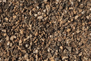 Küçük taşlar, yerde çakıl taşları. Doku. Kahverengi Arkaplan