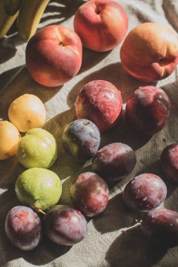 Masadaki olgun, parlak şeftaliler ve erikler