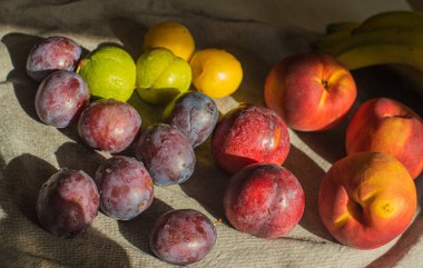 Masadaki olgun, parlak şeftaliler ve erikler