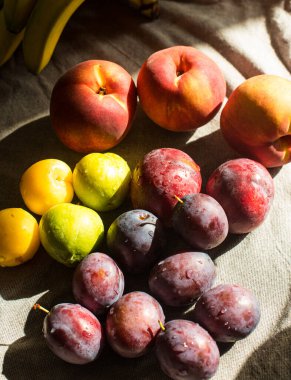 Masadaki olgun, parlak şeftaliler ve erikler