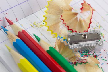 Renkli kalemler ve kurşun kalem çizgili defter kağıt üzerinde keskinleşmiş 