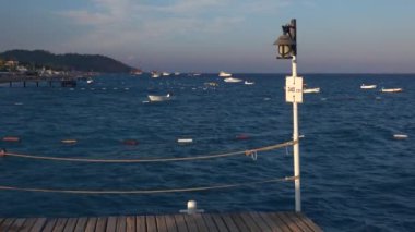 Beyaz dalgalar üzerinde sallanan pier tekne