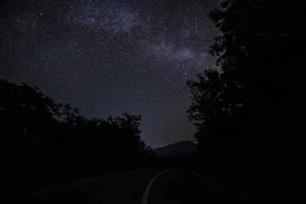 Vía Láctea y la carretera en las montañas — Foto de Stock