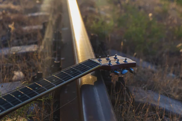 Oude gitaar liggend op de rails — Stockfoto