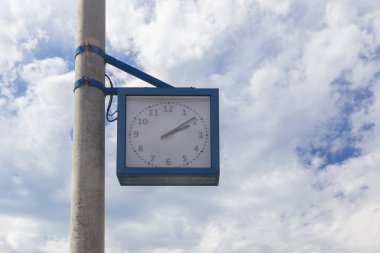 Bulutlu bir gökyüzüne karşı bir sütun üzerinde Saat