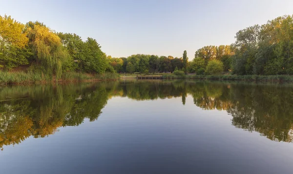 Resting people on the shore of a beautiful pond. — Stock Photo, Image