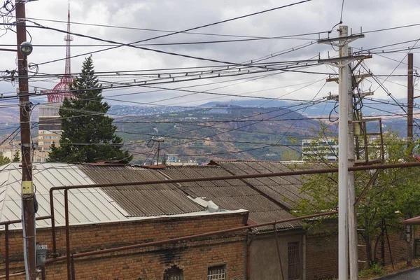 Wires on poles against the background of mountains in Tbilisi — ストック写真