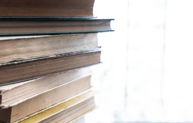 Pencerenin kenarında duran bir yığın eski kitap.