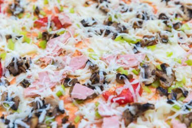 Doğru malzemelerle doldurulmuş ve hazırlanmayı bekleyen bir pizza.