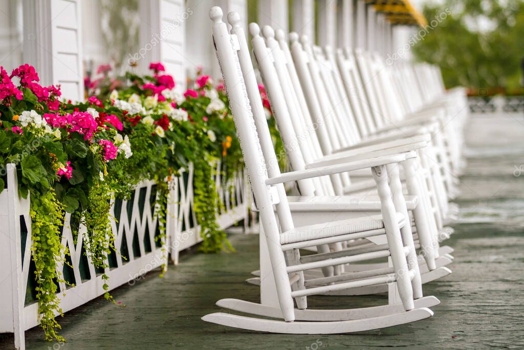 Several White Rocking Chairs on Long Porch just waiting for you to come and enjoy on a luxury trip to Mackinac Island