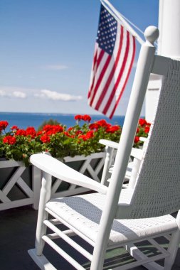 Kızıl sardunyalar, Amerikan Bayrağı ve Sallanan Sandalye fotoğrafı. Mackinac Adası, Michigan.