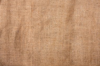 Kahverengi renkli keten liflerin pürüzlü dokumasıyla kumaşın dokusu. Web sayfası ve iç dekorasyon ve tasarım için çuval bezi. El ödevi. Dekorasyon ve giysi