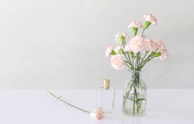 parfüm şişesi karanfil çiçek vazo beyaz tablo ile.