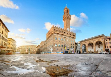 Florence, Italy. View of Piazza della Signoria square with Palazzo Vecchio reflecting in a puddle at sunrise clipart