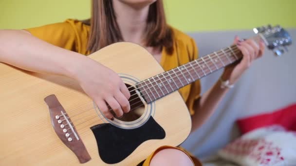 Flicka lära sig att spela akustisk gitarr strängar — Stockvideo