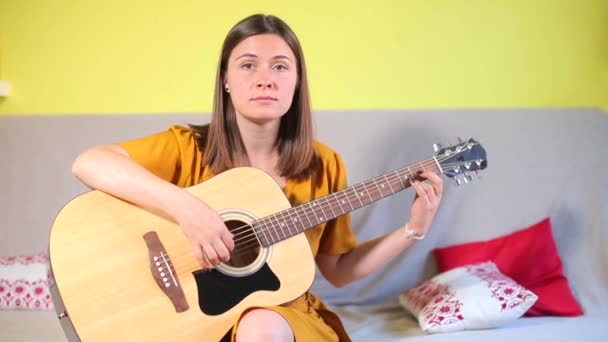 Flicka i musikskolan tar akustisk gitarr examen — Stockvideo