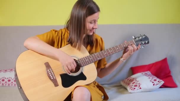 Meisje leert spelen eenvoudige gitaar — Stockvideo