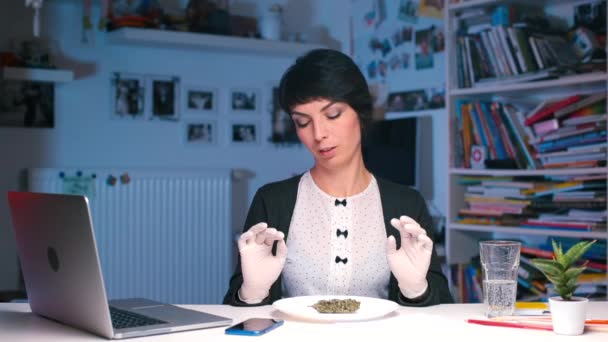 En läkare vid ett skrivbord på sitt kontor studerar egenskaperna hos medicinsk cannabis. — Stockvideo