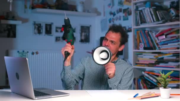 Aggressiv man vid skrivbordet skjuter från en slagskämpe, skriker i en megafon — Stockvideo