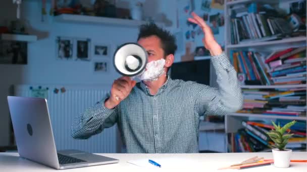 Office worker sitting at desk shouting into a megaphone