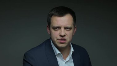 male announcer on dark background says